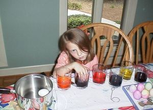 An impatient Emma dying Easter Eggs.